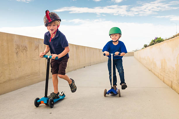 Two Children Racing on Scooters