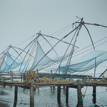Chinese fishing nets, called Shore operated lift nets in other countries. They are lifted as preparation to operate the nets while the sun rises on the Arabian Sea.