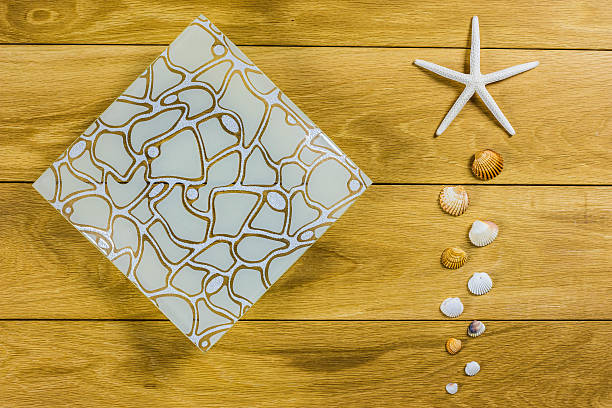 istock Starfish and shells on a wooden background with design plate 625009012