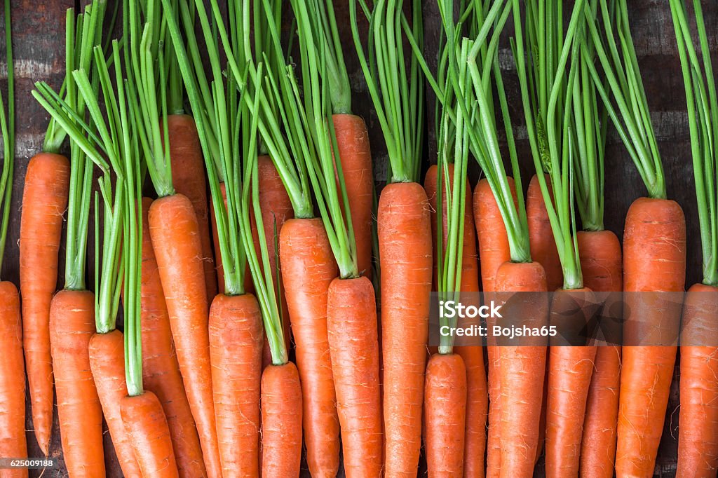 Carrot overhead group lined up on old brown wooden table Carrot colorful overhead group in studio lined up on old rustic brown wooden table Carrot Stock Photo