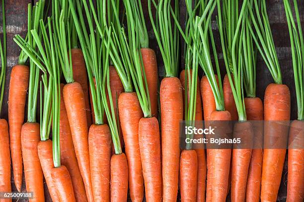 Carrot Overhead Group Lined Up On Old Brown Wooden Table Stock Photo - Download Image Now