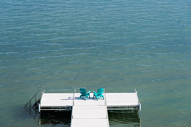 Dock on a lake with Muskoka Chairs