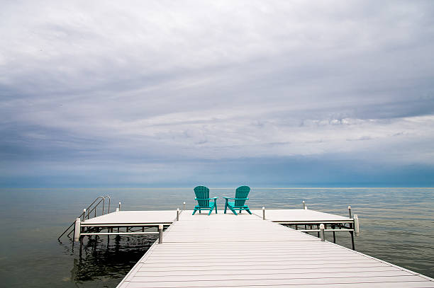istock Cloudy Muskoka Chairs on a dock Adirondack 625010208