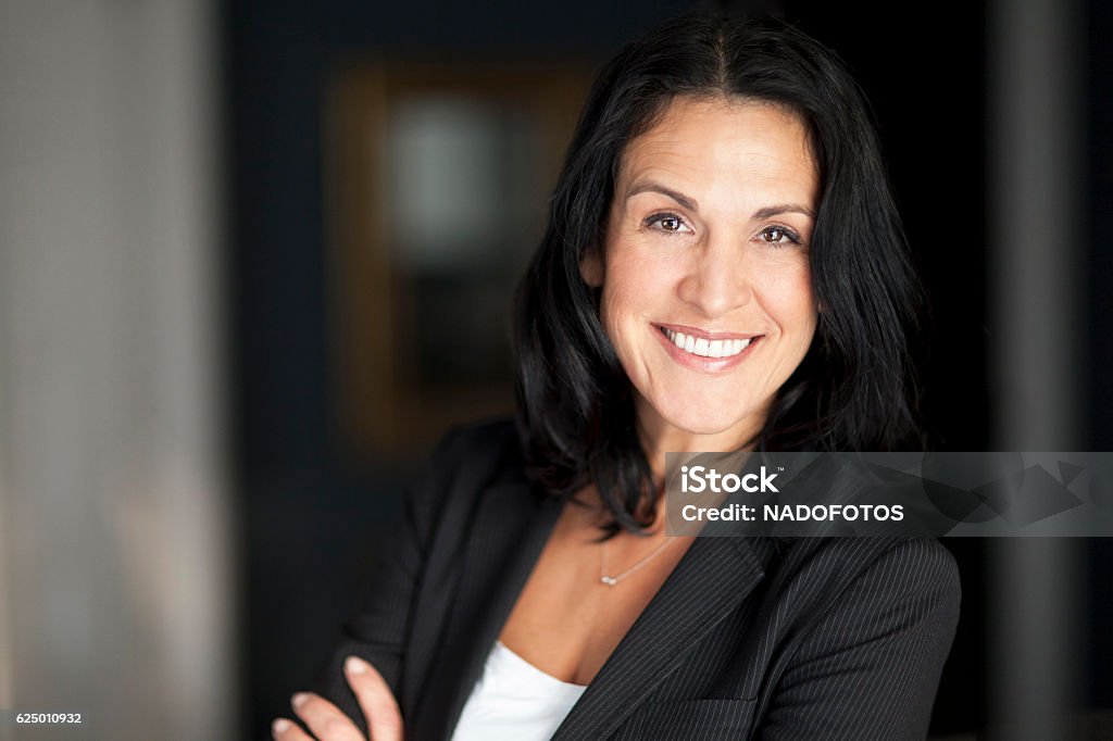 Matura imprenditrice spagnola sorridente alla telecamera. - Foto stock royalty-free di Donna in carriera