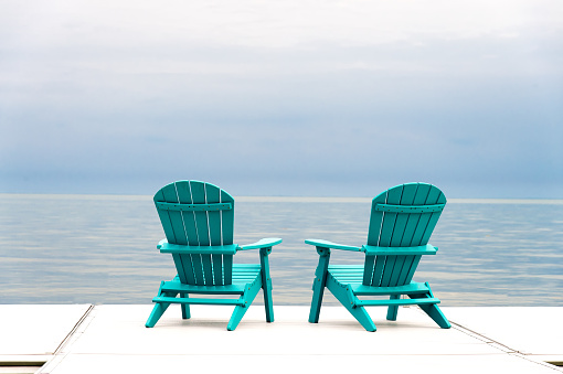Two Adirondack Muskoka Chairs on the water's edge