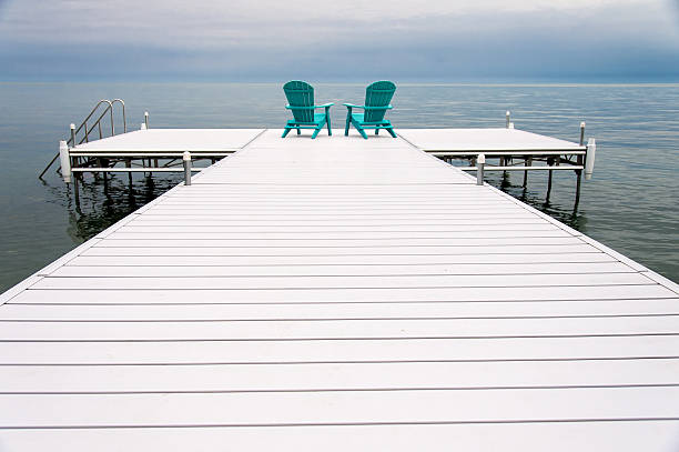 istock Two chairs on the end of a pier 625011054
