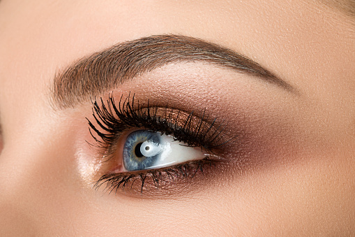 Primer plano del ojo de mujer con hermosos ojos marrones ahumados maquillaje photo