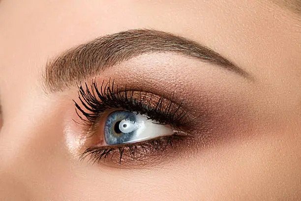 Photo of Close-up of woman eye with beautiful brown smokey eyes makeup
