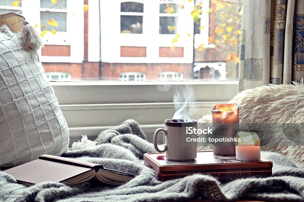 Gemütliches Zuhause. Kerzen, Buch und Tasse Tee - Lizenzfrei Kerze Stock-Foto