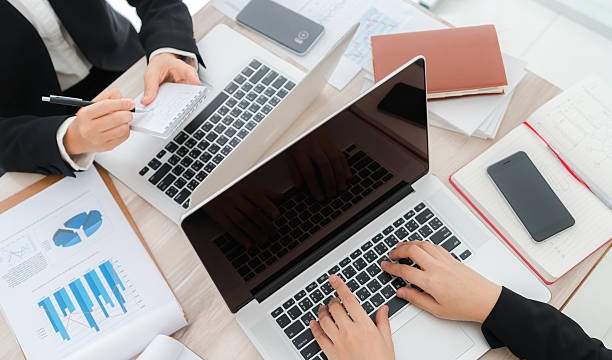 istock People typing on laptops surrounded by financial charts 625050002