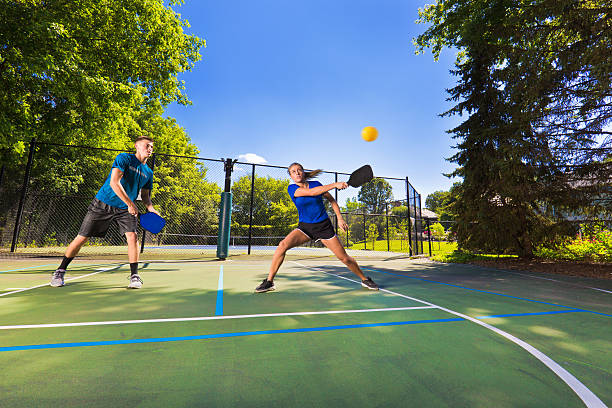 młody mężczyzna i kobieta pickleball pickleball gracza gry na parkiecie - doubles zdjęcia i obrazy z banku zdjęć