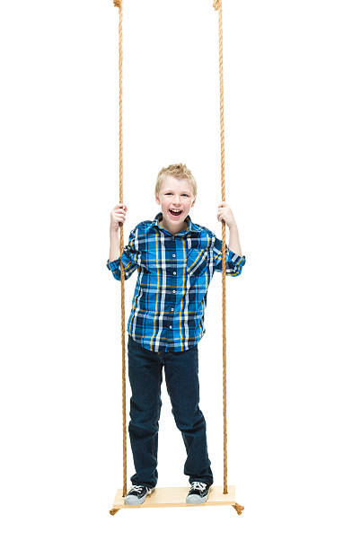 istock Smiling little boy swinging 625058218