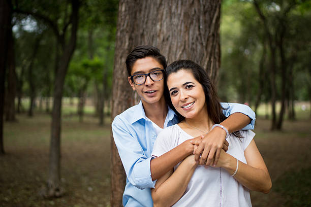 istock Attractive latin mother and teeange son smiling at camera 625061476