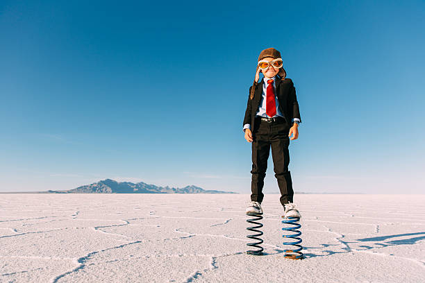 istock Young Boy Businessman Stands on Giant Springs 625063074