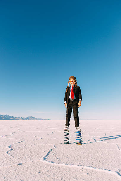 istock Young Boy Businessman Stands on Giant Springs 625063104