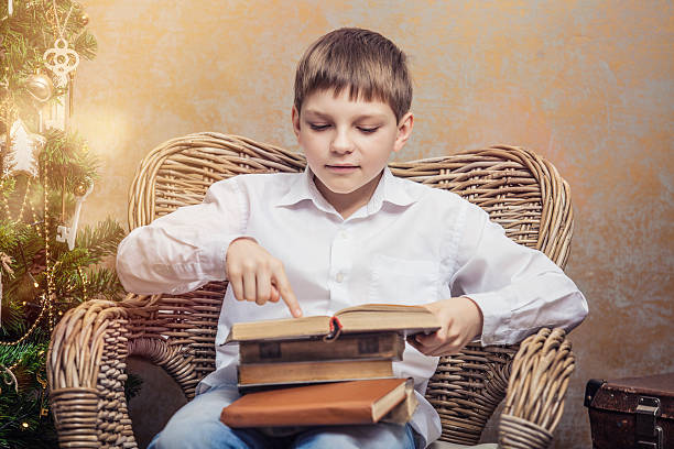 istock Cute baby in a chair reading a book in interior 625065422