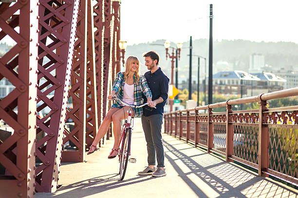 istock Young romantic couple flirting on a bicycle on a bridge 625069418