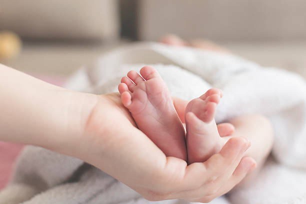 istock Mothers hand holding baby feet 625069858