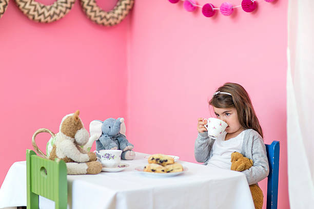 niña que tiene una fiesta de té con sus peluches - tea party party tea little girls fotografías e imágenes de stock