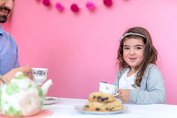 istock Young girl with pretty eyes drinking tea with dad 625070172