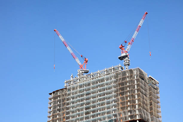istock Crane and building construction site against blue sky 625081556