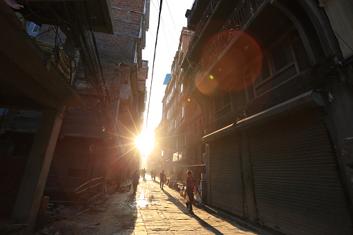 Kathmandu, Nepal - October 20, 2016: Nepali people walking down the Thamel street under sunrise in the morning in Kathmandu, Nepal