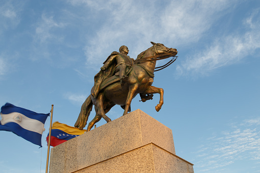 Managua, Nicaragua – March 07, 2016: Simon Bolivar statue with venezuela flag in Puerto Salvador Allende