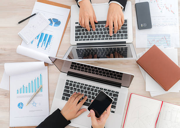 istock People typing on laptops surrounded by financial charts 625095712
