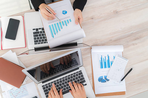 istock People typing on laptops surrounded by financial charts 625095876