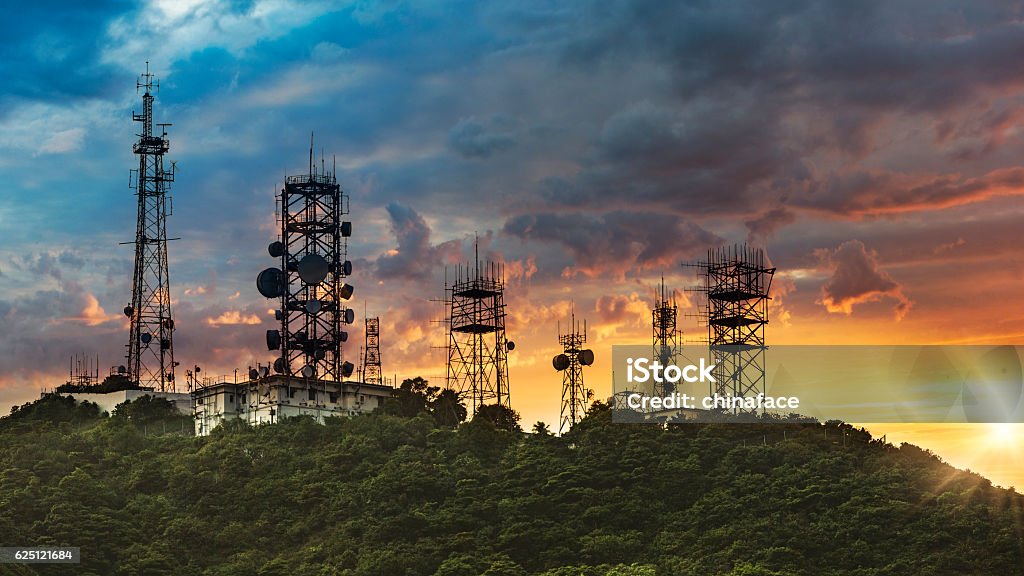 夕日の背景を持つシルエットアンテナのけち - 通信設備のロイヤリティフリーストックフォト