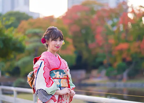 Young woman wearing Furisode in autumn foliage