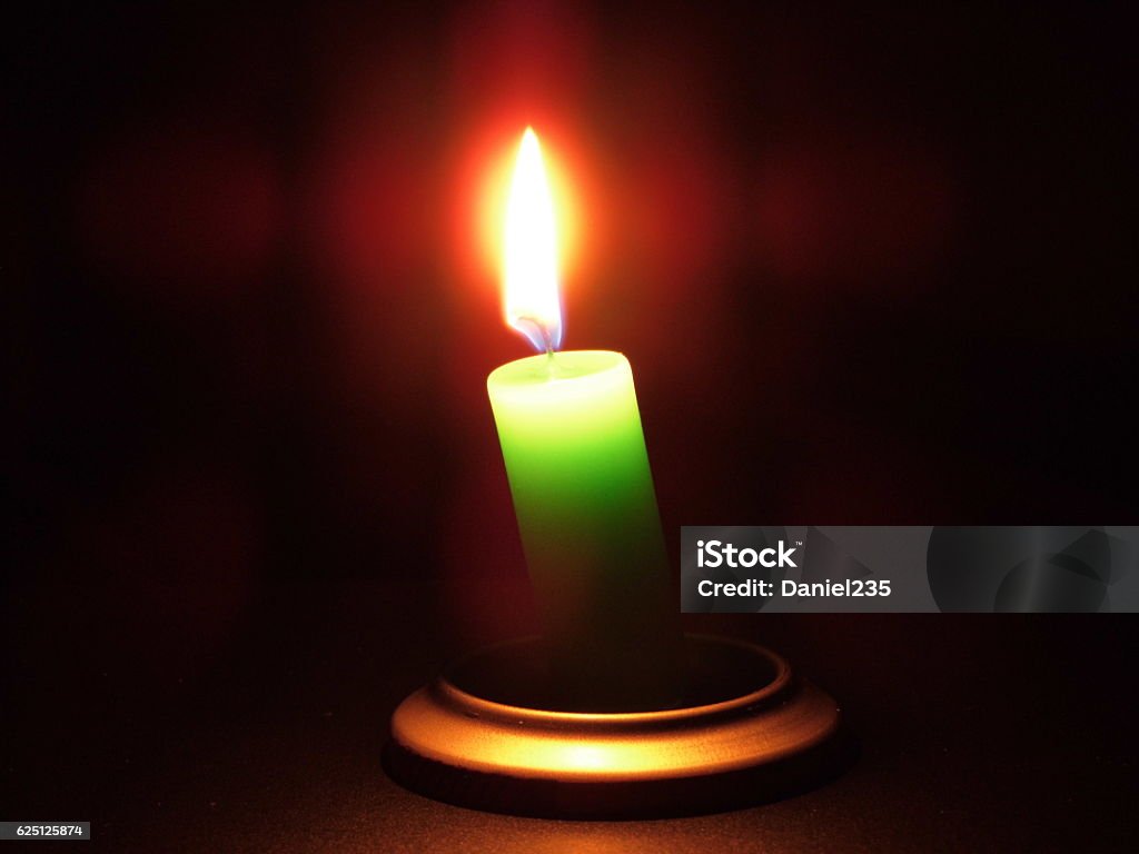 mystery Photograph of a lit green candle Ceremony Stock Photo