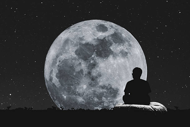 istock Silhouette a man sitting relaxing under full moon at night 625130198