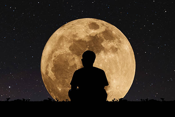 istock Silhouette a man sitting relaxing under full moon at night 625130312