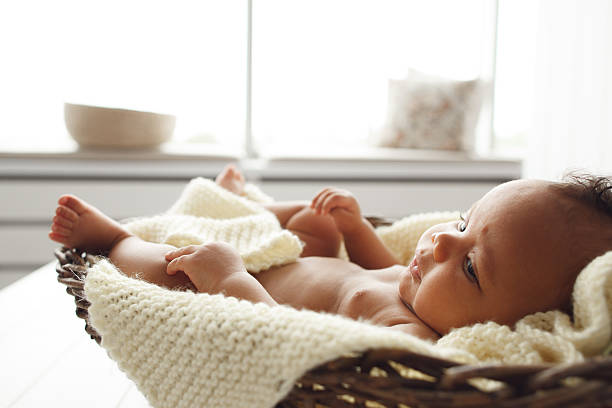 istock Adorable baby lying in wicker cradle by window 625135480
