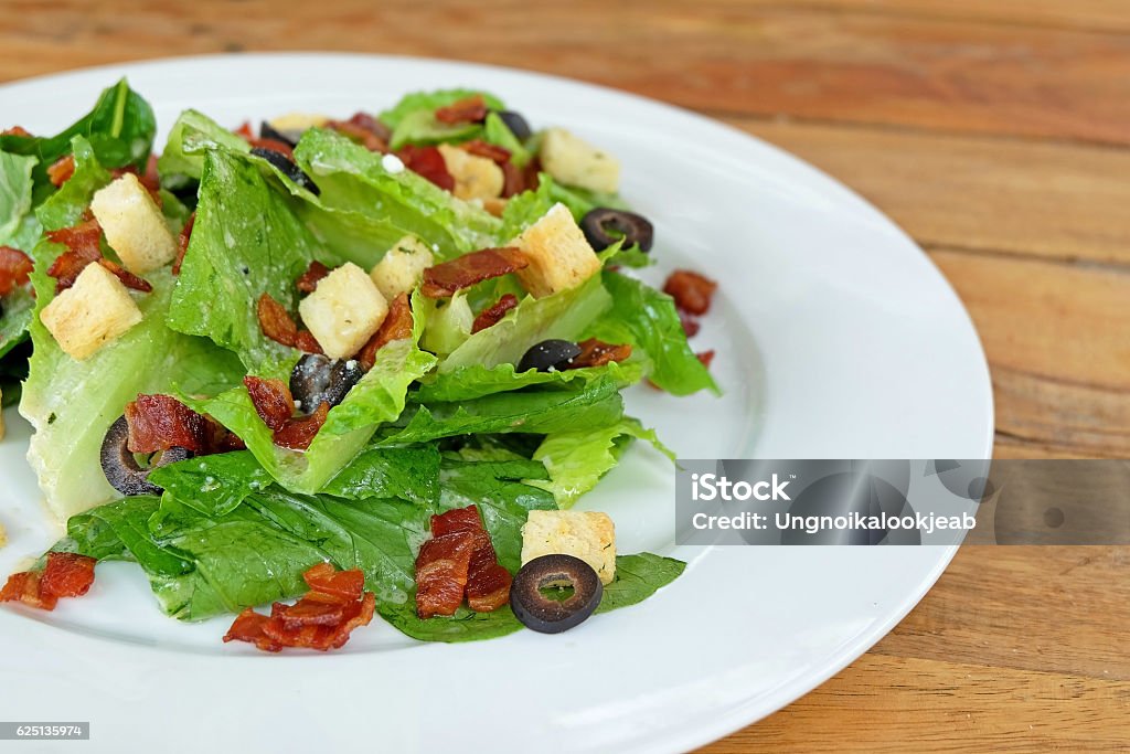 caesar salad Closed up cropped caesar salad topping with crispy bacon and crouton Animal Egg Stock Photo