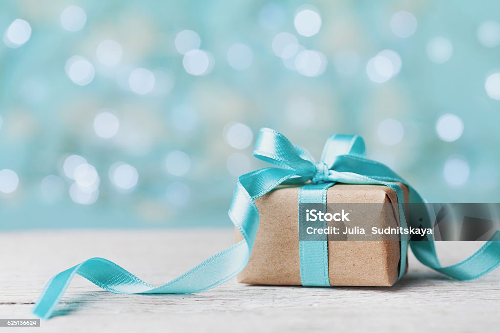 Boîte-cadeau de Noël sur fond de bokeh turquoise. Concept de vacances. - Photo de Cadeau libre de droits