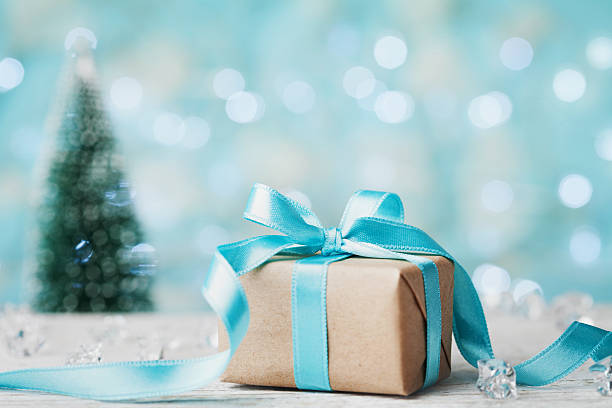 istock Christmas gift box and blurred fir tree against blue bokeh. 625144226