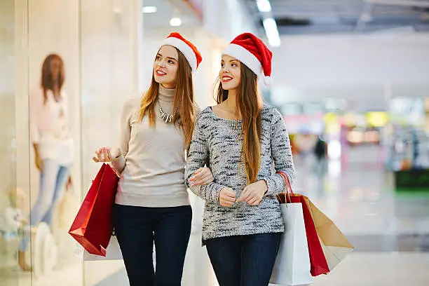 Christmas girls buying presents in shopping-center