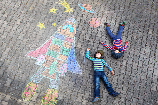 istock Two little kid boys flying by space shuttle chalks picture 625150442