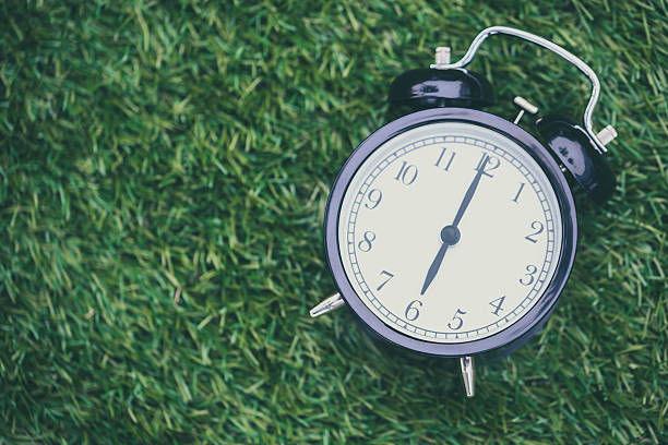 istock times retro clock lay on green grass nature 625156906