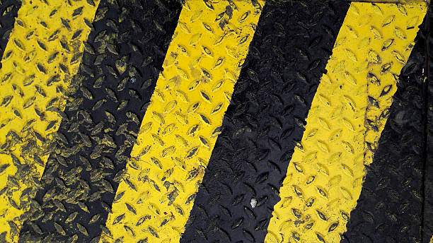 istock Black and yellow line paint on non-slip metal background 625157498