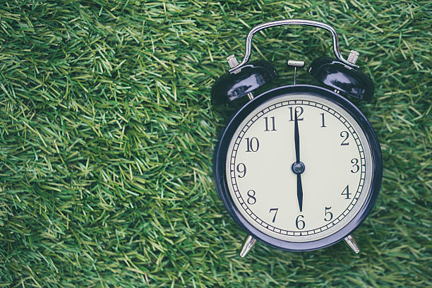 istock times retro clock lay on green grass nature 625157758