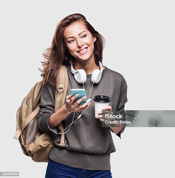 Foto de Jovem Estudante Feliz Usando Telefone Inteligente e mais fotos de stock de Estudante - Estudante, Mulheres, Figura para recortar