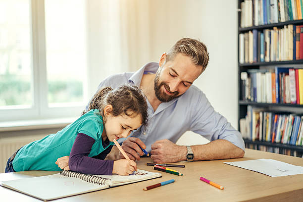 istock father and daughter drawing together at home 625166016