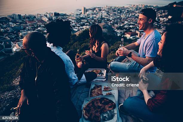 Group Of Young Adult Friends Having Picnic With Pizza At Stock Photo - Download Image Now