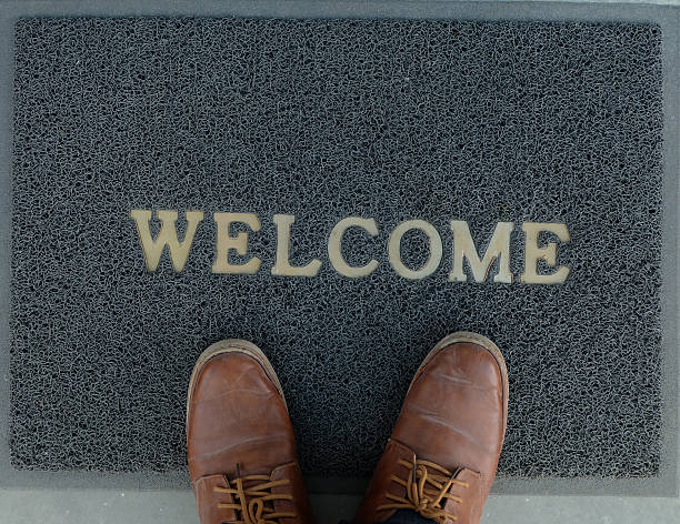 Welcome carpet with foot-ware on it stock photo