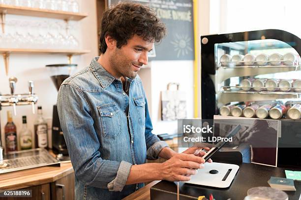 In Restaurant The Waiter Prepares The Bill On Tablet Pc Stock Photo - Download Image Now