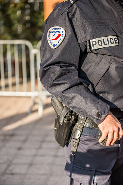 французский полицейский, вид на руку рядом с пистолетом - weapon gun order handgun стоковые фото и изображения