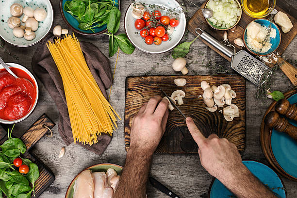 Male hands preparing ingredients for pasta on a wooden table